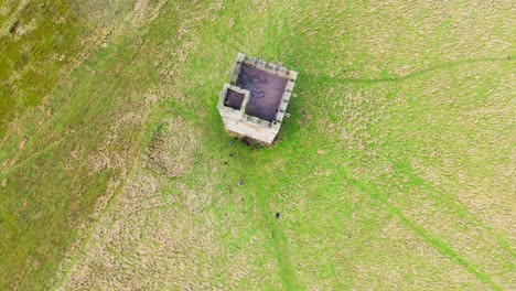 Altes-Verfallenes-Schloss,-Denkmal,-Stillgelegter-Steinturm,-Mit-Leuten,-Die-Herumlaufen-Und-Eine-Drohne-Fliegen