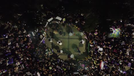 Night-aerial-rises-above-protestors-in-Santa-Cruz-Bolivia,-Women's-Day