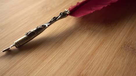 Feather-Pen-on-Wood-Background-Rotates