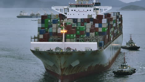 Rusty-Cosco-container-vessel-accompanied-by-tug-boats---parallax-shot