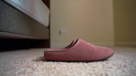 Close-up-woman's-foot-wearing-a-slipper-on-carpet-in-the-morning