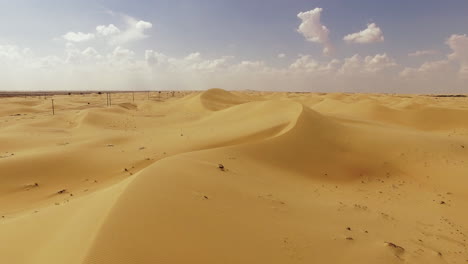 An-awe-inspiring-sight-unfolds-at-Al-Wahthba,-Abu-Dhabi,-where-the-sand-dunes-gleam-with-their-stunning-yellowish-brown-hue,-serving-as-the-backdrop-for-camel-races