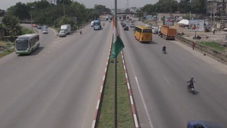 Bandera-De-Costa-De-Marfil-Ondeando-En-Un-Poste-En-Medio-De-Una-Carretera