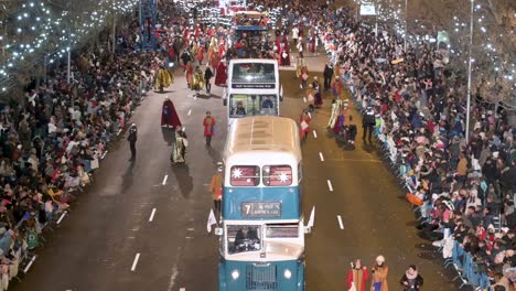 Float-riders-and-buses-at-the-Three-Wise-Men-festival,-also-known-as-the-Three-Kings-Parade,-join-families-and-spectators