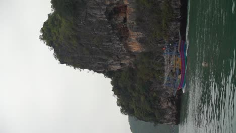 Traditional-Thailand-fishing-vessel-leaving-for-workday,-vertical-view