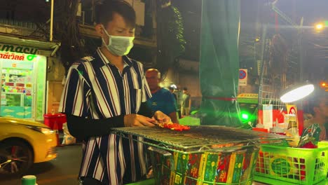 Busy-Street-food-vendor-cooking-grilled-pork-and-beef-meat-on-grill-Bangkok