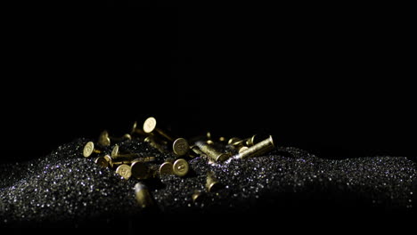 .22-Long-Rifle-bullets-on-gunpowder-dust-against-black-background,-circle-pan