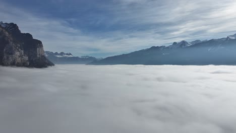 Misty-Cliffs-Over-Weesen,-Switzerland---aerial-above-the-clouds