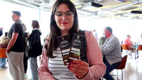 Woman-holding-free-beer-tickets-at-Gravity-Bar,-Dublin