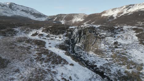 La-Cascada-Del-Velo-De-La-Novia-En-La-Isla-De-Skye,-Nieve-Ligera-Que-Cubre-El-Terreno-Accidentado,-Temporada-De-Invierno,-Vista-Aérea