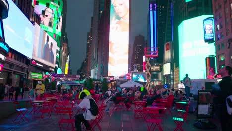 Die-Leute-Sitzen-Wie-Gebannt-Vor-Den-Grellen-LED-Bildschirmen-Des-Times-Square-In-Der-Nacht