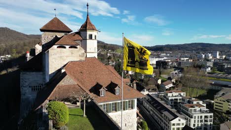 Aarburg-Aargau-Switzerland-closeup-of-castle-flag-crest-in-the-wind-aerial