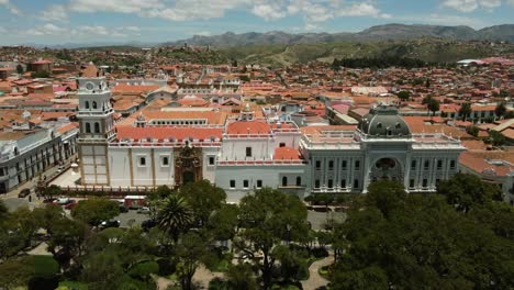Aerial-retreats-from-Basilica-to-reveal-May-25-Plaza-in-Sucre,-Bolivia