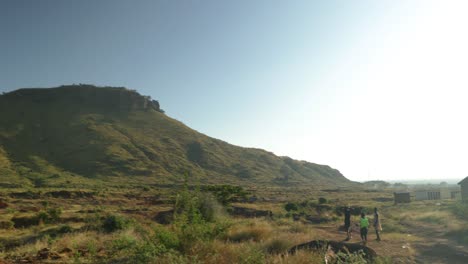 Los-Niños-Pequeños-De-Una-Aldea-Remota-Caminan-Por-Un-Paisaje-De-Montaña.