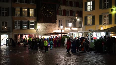 Crowd-of-celebrating-people-outdoors-in-front-of-restaurants-at-night