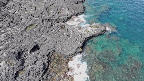 Vista-De-Drones-Mirando-Hacia-Abajo,-Flotando-Sobre-La-Costa-Rocosa-De-Pointe-Au-Sel-En-Saint-leu,-Isla-De-La-Reunión,-Con-Un-Lento-Movimiento-Hacia-Adelante