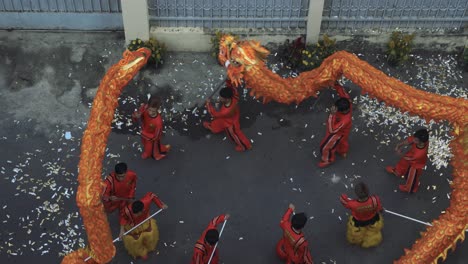 Year-of-Dragon-dance-performance-in-a-small-street-in-Ho-Chi-Minh-City,-Vietnam-from-top-down-view