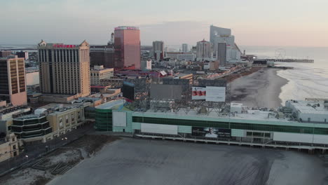 Drohne-Fliegt-In-Richtung-Caesars-Atlantic-City-Casino-Mit-Sonnenaufgang,-Der-Sich-In-Den-Fenstern-Spiegelt