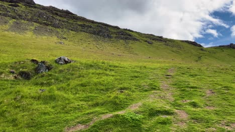 Rocky-hills-and-green-meadows-of-Iceland,-panning-view