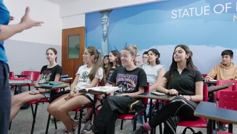 moving-shot-of-a-class-inside-a-classroom-with-caucasian-teenage-students-having-fun-while-a-teacher-explains-the-lesson