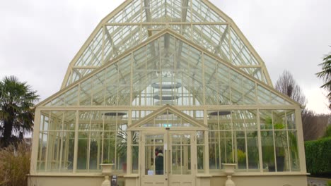 Large-glass-greenhouse-in-the-Botanic-Gardens-of-Dublin,-cloudy-day