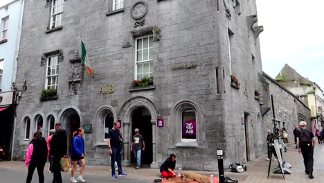 People-passing-by-old-Lynch's-Castle--in-Galway