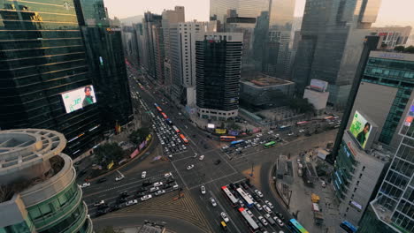 Kreuzung-Der-Station-Gangnam,-Riesiger-Geschäftiger-Autoverkehr-Im-Zeitraffer-Bei-Sonnenuntergang,-Hauptstraße-Von-Seoul-Mit-Hoch-Aufragenden-Bürogebäuden-–-Blick-Vom-Dach