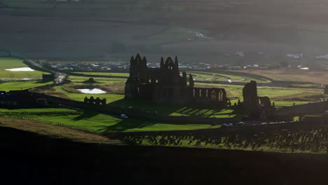 Establishing-Long-Lens-Drone-Shot-of-Whitby-Abbey-Looking-Over-Land-UK
