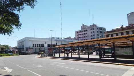 Old-Truck-Drives-By-Federico-Lacroce-Railway-Station-in-Buenos-Aires-Argentina-Street-Landmark,-Buses,-Cars-and-Traffic-at-Avenue-in-Argentina,-Plaza-Los-Andes,-Chacarita