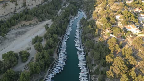 Aerial-View-of-Moored-Boats-and-Sailboats-in-Bay-of-Calanque-National-Park,-French-Riviera,-Revealing-Drone-Shot