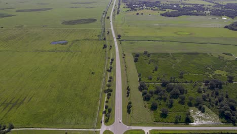 Vista-Aérea-De-La-Carretera-A-Lo-Largo-De-Campos-De-Cítricos.