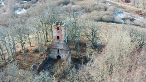 Aerial-approach-toward-abandoned-countryside-church-tower-and-wall-remains