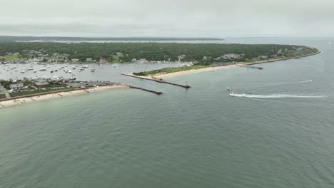 Drone-shot,-boat-entering-a-marina-in-Cape-Cod,-Massachusetts