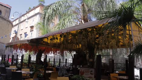 Canopy-covered-shaded-dining-area-in-urban-street-on-windy-day