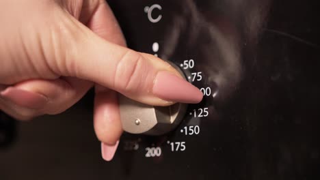 Turning-temperature-dial-on-oven-Close-Up