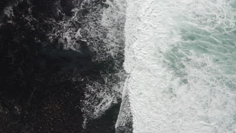 4K-cinematic-overhead-of-foamy-white-waves-breaking-over-a-lagoon-full-of-kelp-on-the-California-Coast