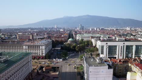 Busy-city-life-in-Sofia,-Bulgaria-with-famous-ancient-church,-aerial-skyline