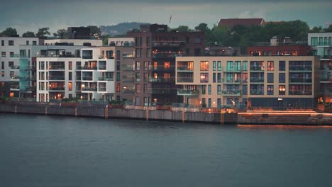 Moderne-Wohngebäude-Mit-Hell-Erleuchteten-Fenstern-Im-Küstenviertel-Der-Stadt-Kristiansand