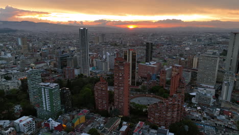 Drone-shot-backwards-over-the-Santa-Fe-district-of-Bogota,-sundown-in-Colombia