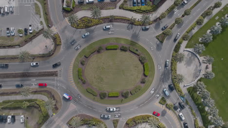 Top-down-aerial-view-of-cars-going-around-a-busy-traffic-roundabout