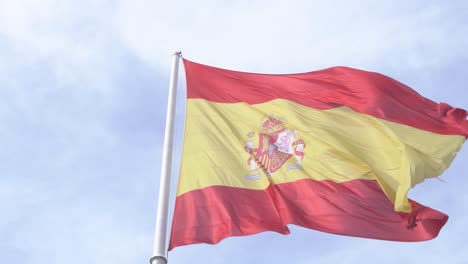 Detailaufnahme-Der-Spanischen-Flagge,-Die-In-Zeitlupe-Im-Wind-Weht,-Mit-Blauem-Himmel-Und-Wolken-Im-Hintergrund,-Nahaufnahme-Der-Spanischen-Flagge