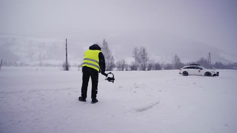 Videographer-with-bright-yellow-safety-vest-use-camera-to-film-drift-event