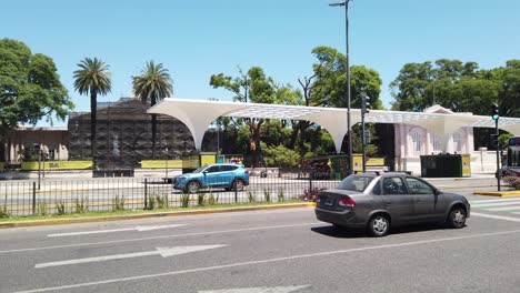 Der-Verkehr-Fährt-Am-Chacarita-Friedhof-Vorbei,-Im-Sommer-An-Der-Skyline-Der-Avenue-Federico-Lacroce-Im-Berühmten-Barrio-Der-Hauptstadt,-Einem-Stadtviertel-In-Südamerika,-Der-Stadt-Buenos-Aires,-Argentinien