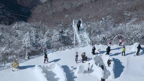 Blick-Auf-Den-Balwangsan-Ki-Skywalk-Auf-Die-Menge-Der-Touristen,-Die-Den-Schneebedeckten-Mona-Park-Besuchen---Zeitlupe