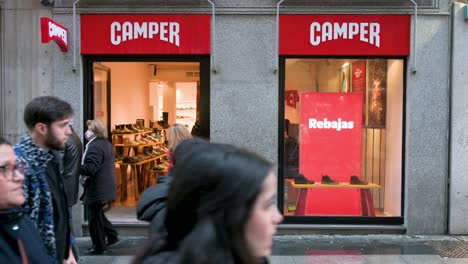 La-Gente-Pasa-Por-La-Multinacional-Española-De-Fabricación-Y-Venta-Al-Por-Menor-De-Calzado-Camper-Store-En-Madrid,-España