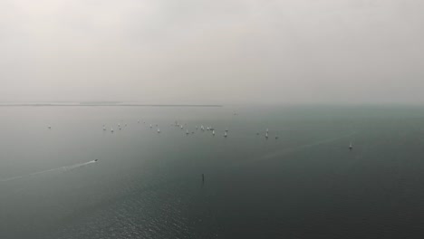 An-extremely-wide-shot-of-a-sailboat-race-in-overcast-weather
