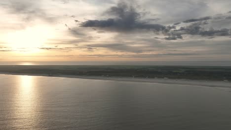 Aerial-drone-shot-of-the-beach-shore-line-of-Ameland-in-the-Netherlands-during-a-beautiful-sunrise