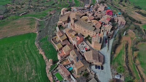 Drone-flight-over-medieval-village-Florejachs-and-green-fields
