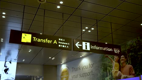 En-Las-Salidas-De-La-Terminal-3-Del-Aeropuerto-Changi-De-Singapur,-Las-Señales-Indican-Los-Puntos-De-Transferencia-Y-Brindan-Información,-Lo-Que-Representa-La-Esencia-De-Los-Viajes-Aéreos-Y-Los-Desplazamientos-Diarios.