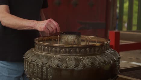 Male-Tourist-lighting-incense-sticks-at-the-temple-of-Todai-ji